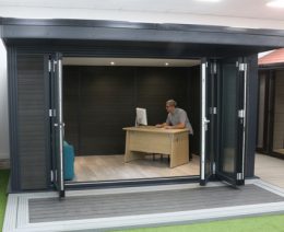 Man at desk with computer in office garden room